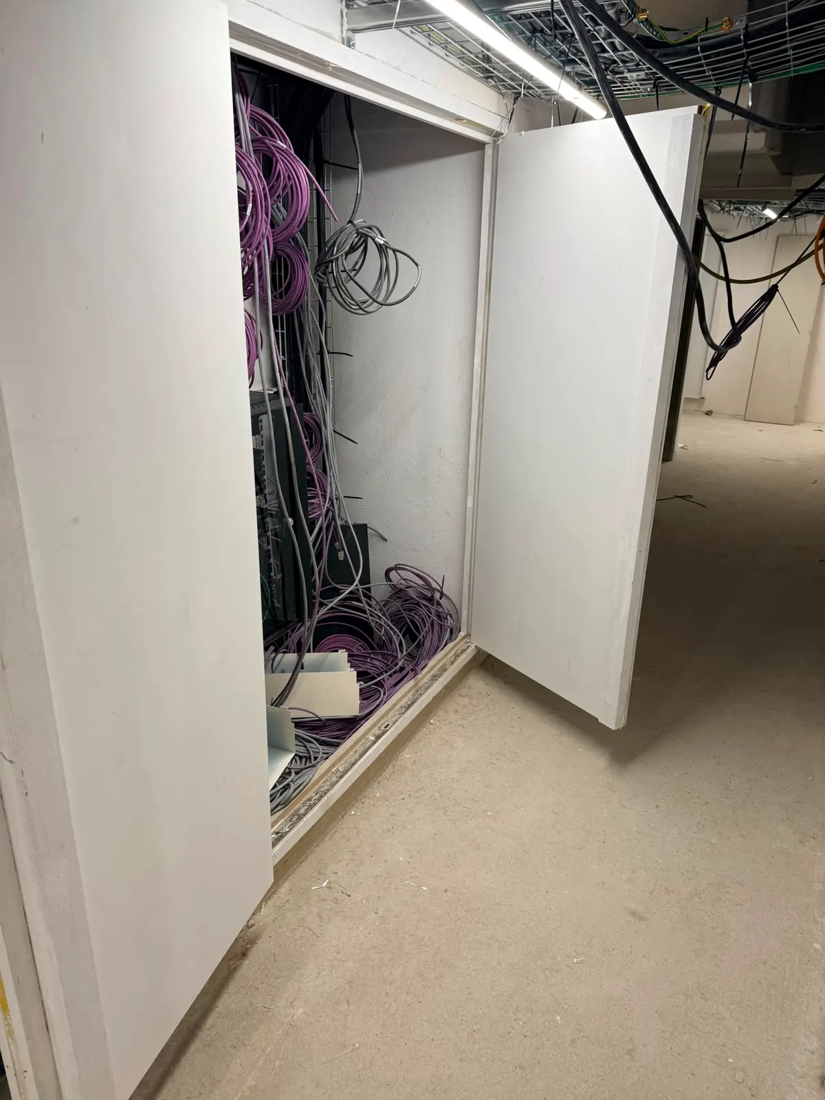 Armoire technique ouverte avec arrivée de câbles réseau