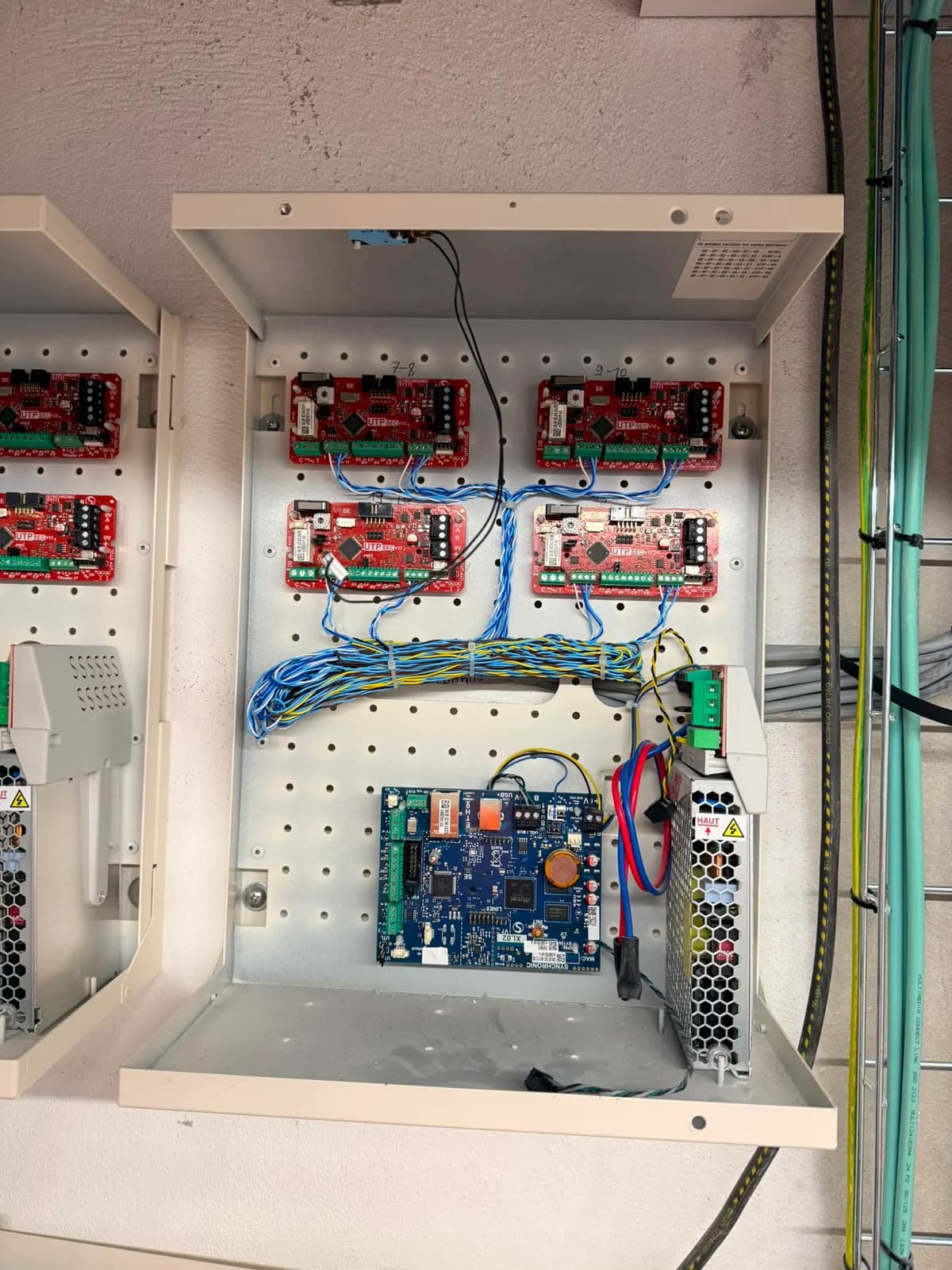 Coffret équipé de modules de contrôle rouges, d'une carte bleue et d'une alimentation
