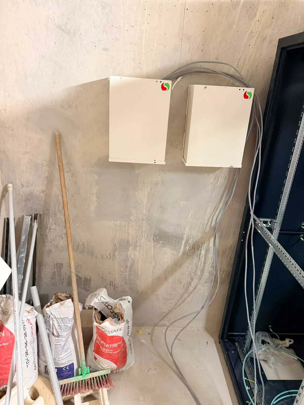 Deux coffrets fermés installés au mur d'un local technique